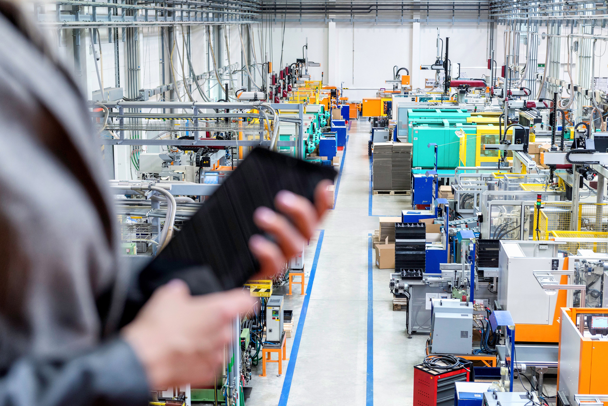 Worker holding tablet inside factory