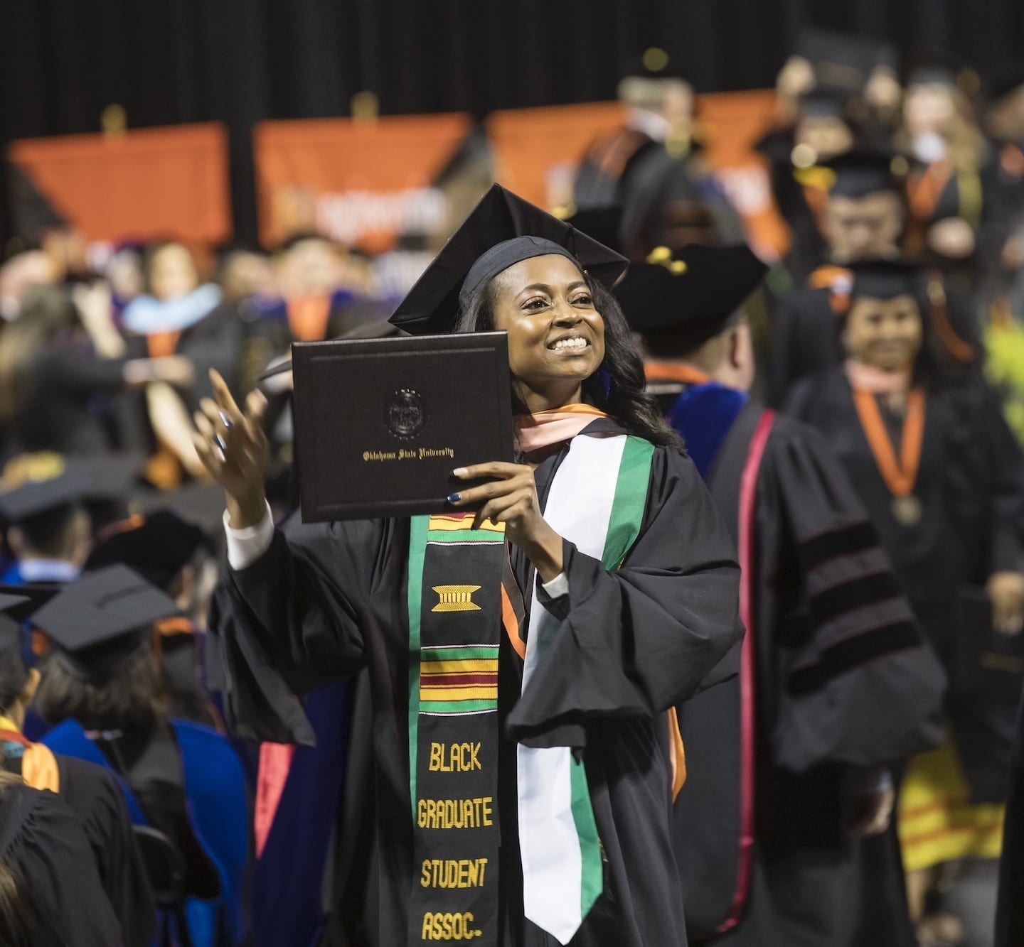 OSU student holding diploma at graduation