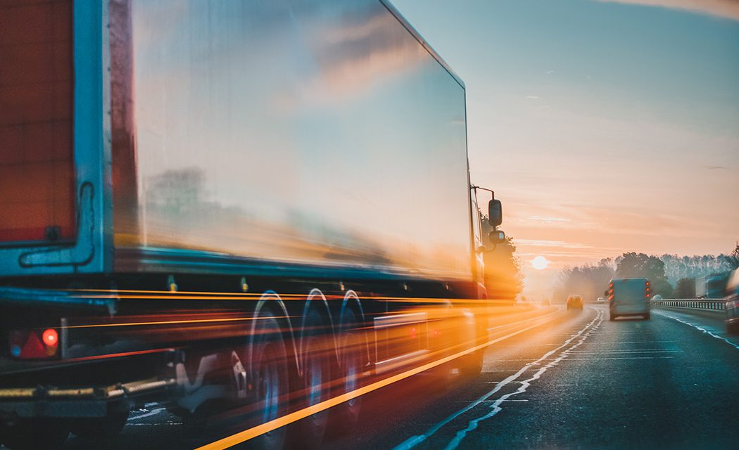 Truck driving down road with yellow lights blurring