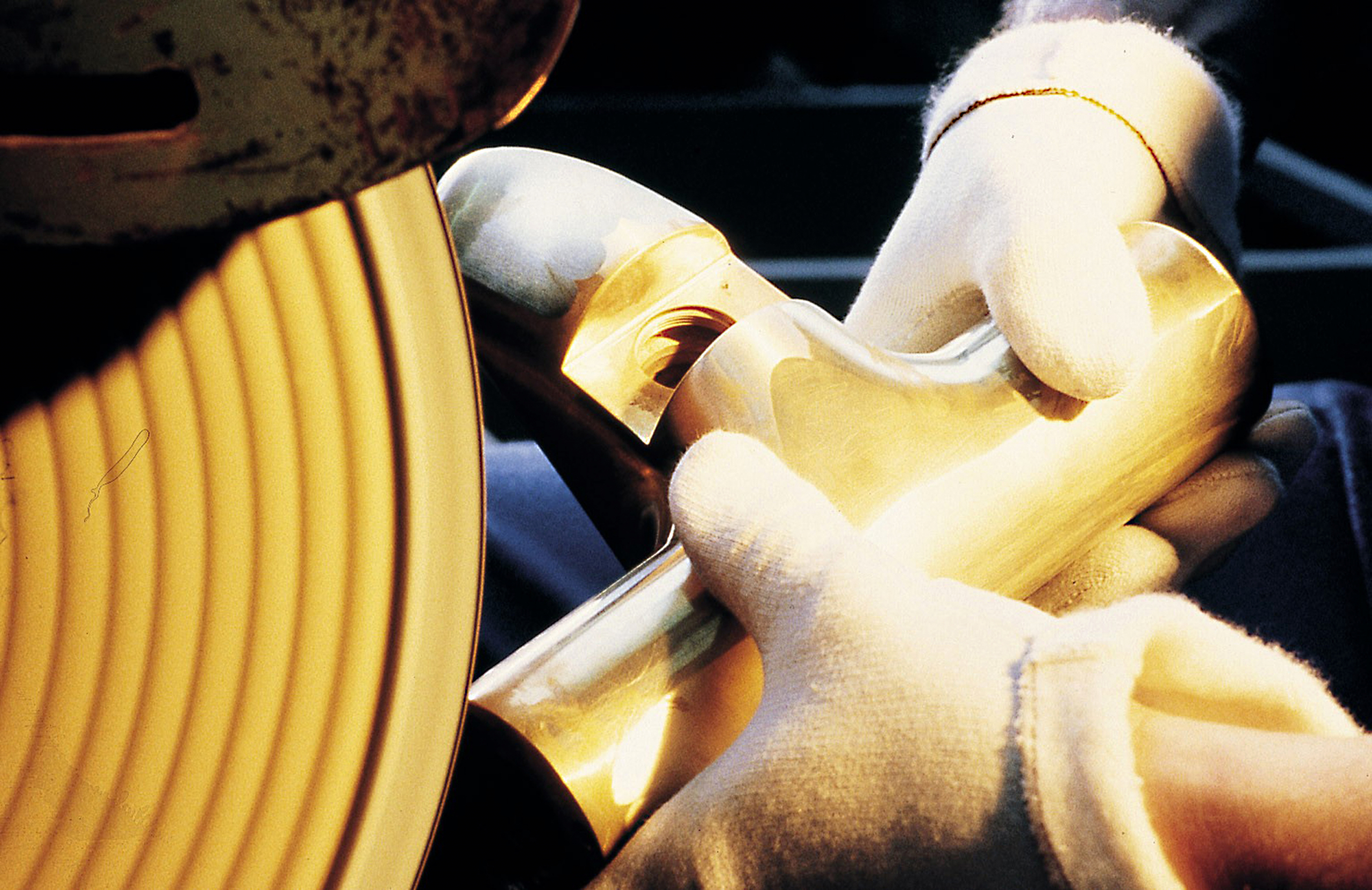 Worker with gloves holding metal part